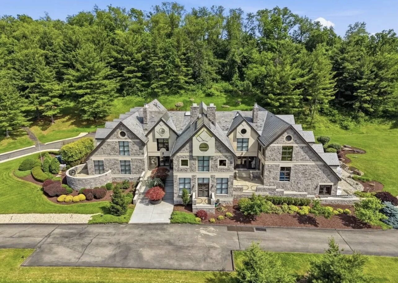 Stone manor home set against wooded hillside, South Hills Pittsburgh luxury real estate
